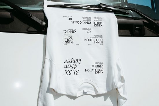White t-shirt mockup on a car windshield with text designs, perfect for presentations in mockups, apparel design, and advertising.