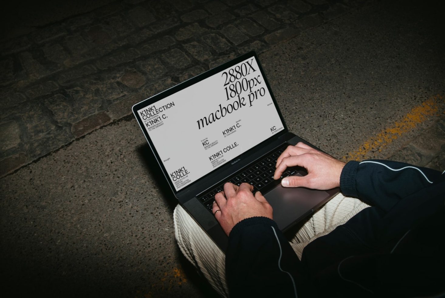 Person using laptop with graphic design mockup on screen at night, designer working on a digital template for branding.