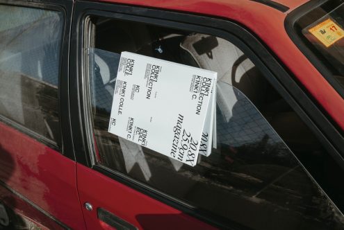 Alt: Stack of magazines with stylish typography design placed inside a red car, showcasing mockup potential for layout presentation.