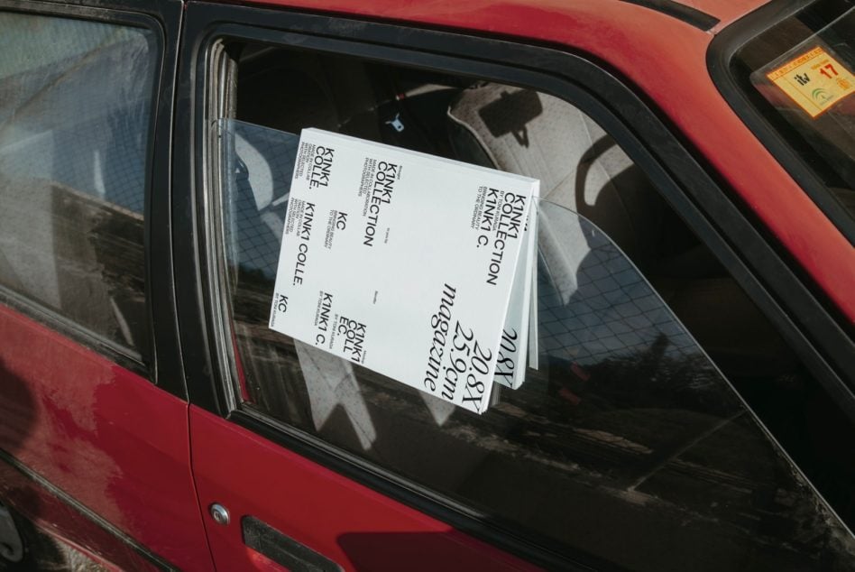 Stacked magazines showing in red car window with visible interior