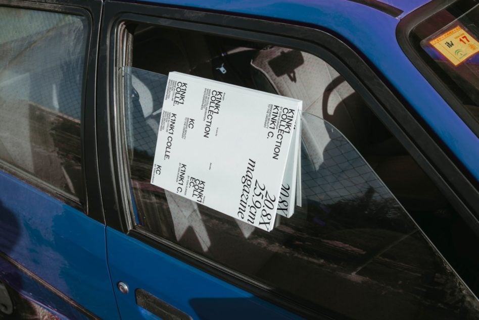 Leaflets taped to car window showing Kinki Collection branding with typography