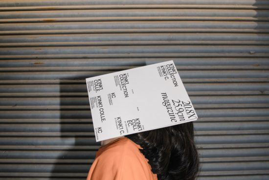 Person with magazine covering face against corrugated metal background, creative editorial mockup design template for display.