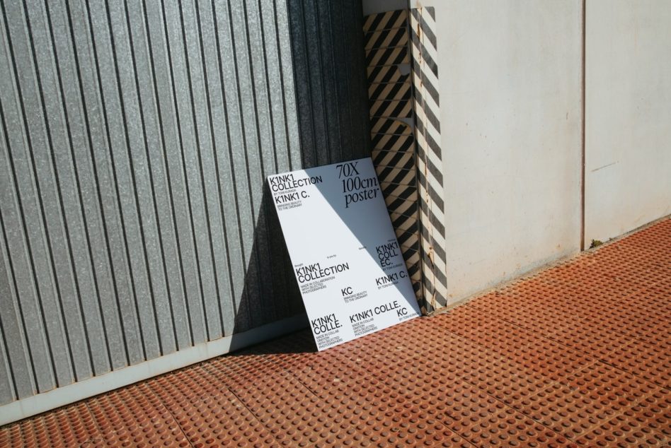 K1NK1 poster leaning between corrugated metal wall texture