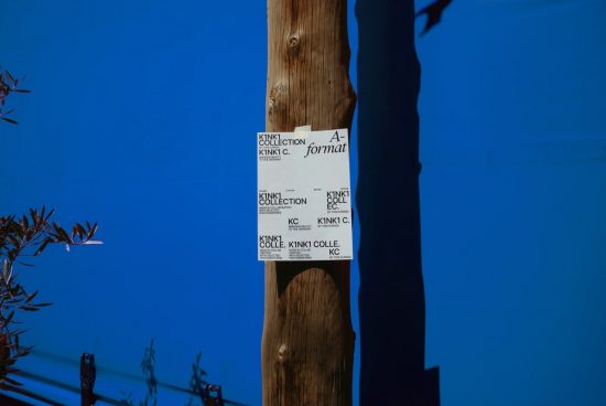 Weathered wooden pole with torn posters against a blue sky, ideal for graphic design mockups related to urban texture and typography.