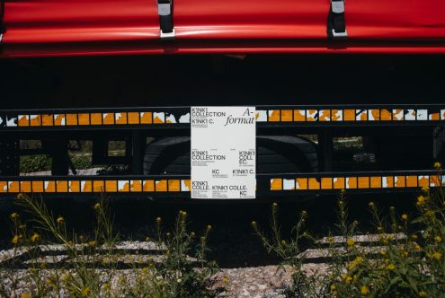 Red kayak on a rack displaying a black and white typography poster for a design collection, surrounded by natural scenery. Perfect for Mockups, Graphics.