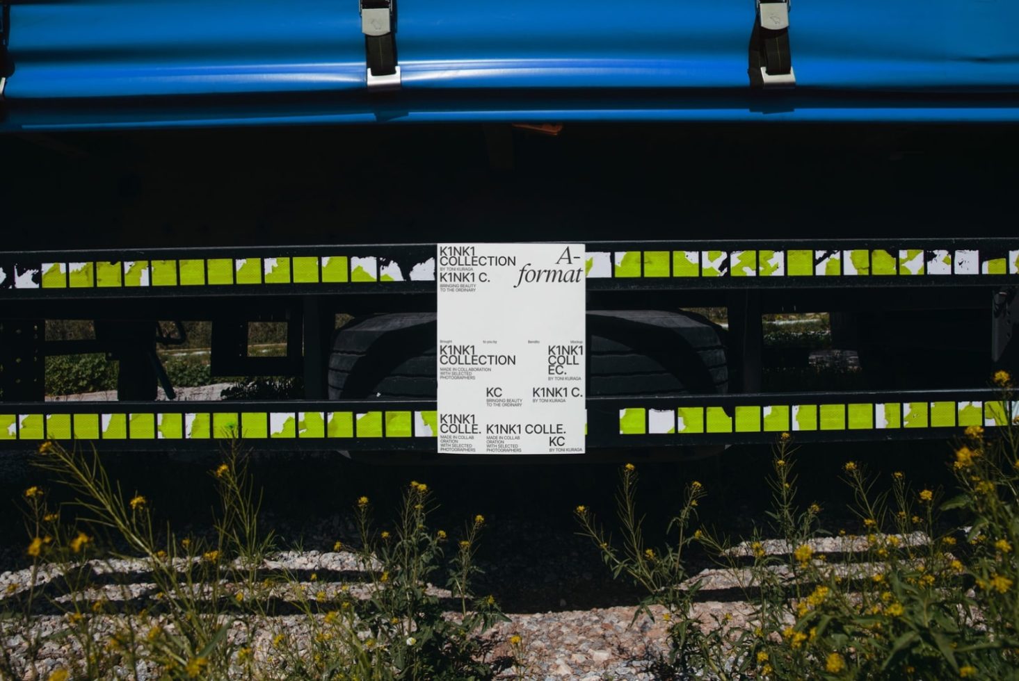 Poster mockup displayed under a blue kayak on wooden pallet with nature background, ideal for presenting outdoor advertising designs.