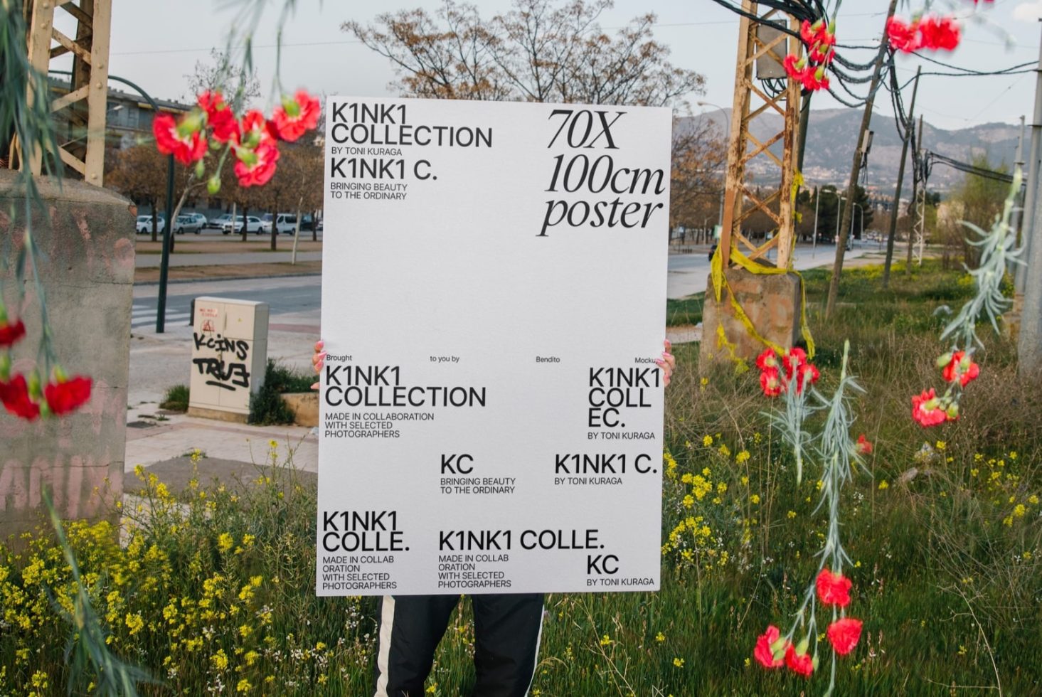 Large blank poster mockup held outdoors with floral foreground, ideal for designers looking to present advertisements or artwork.