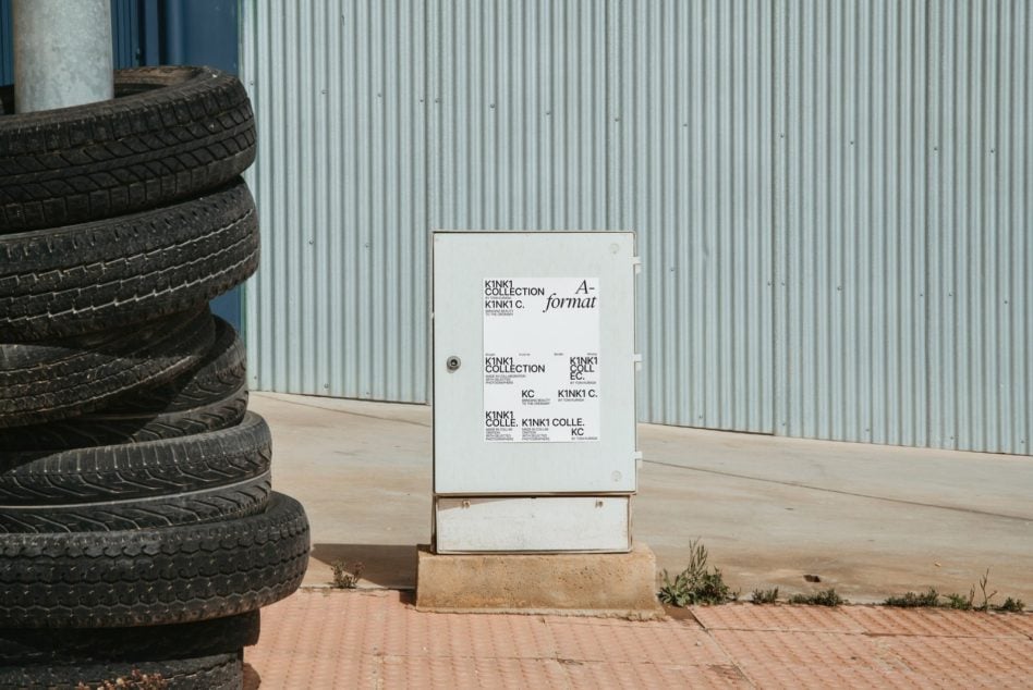 Stacked poster mockup with branding layouts displayed on concrete blocks next to old tires in industrial setting
