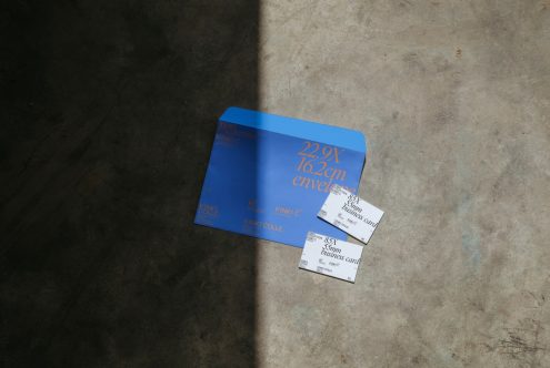 Blue envelope mockup and white business cards on textured background for presentation and branding designs.