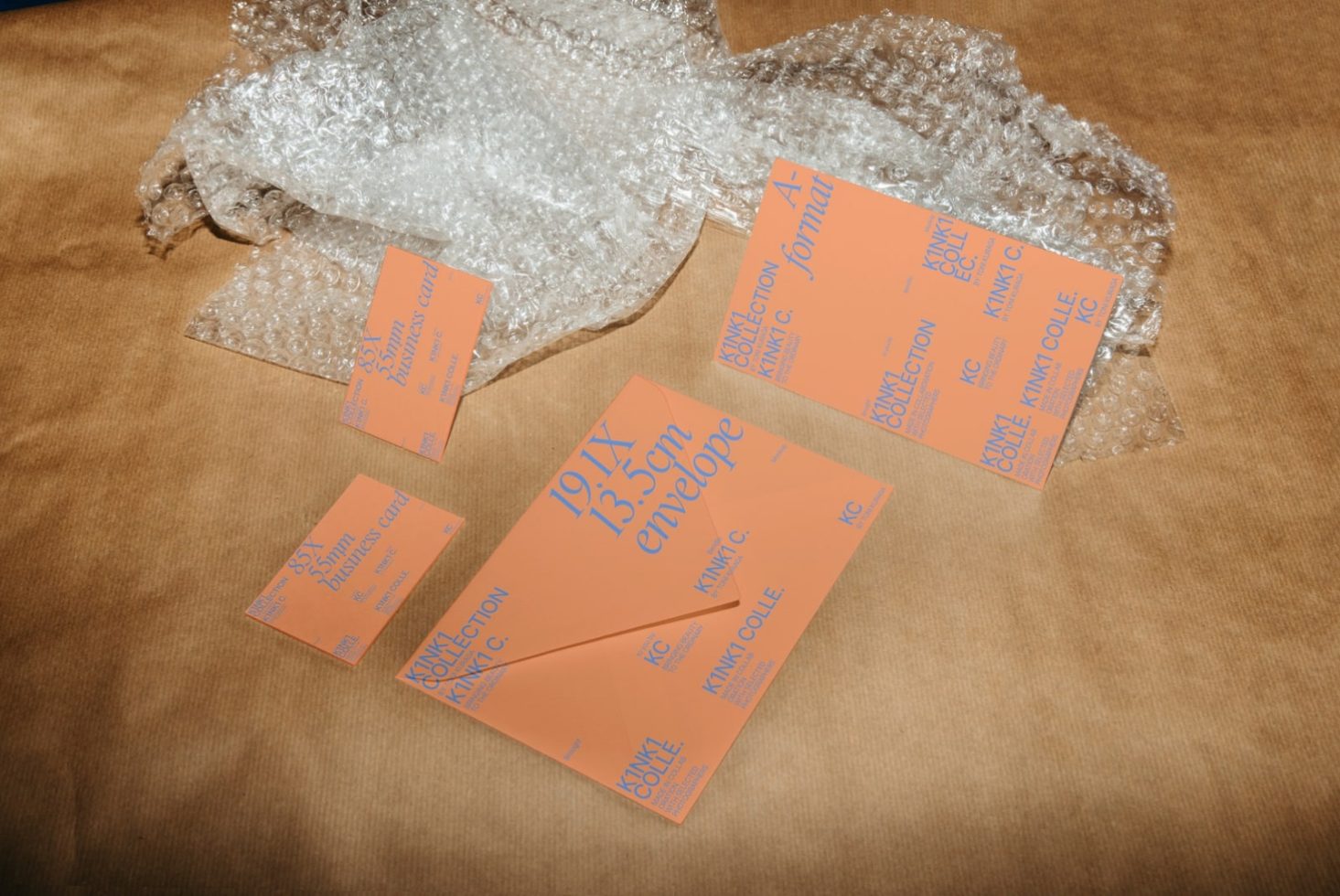 Orange business cards mockup on a textured background with bubble wrap, showcasing modern design and typography for templates category.