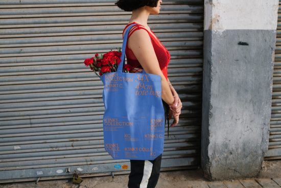 Woman standing with branded tote bag and red flowers, stylish outdoor mockup for presentations, side view, urban fashion accessory design.
