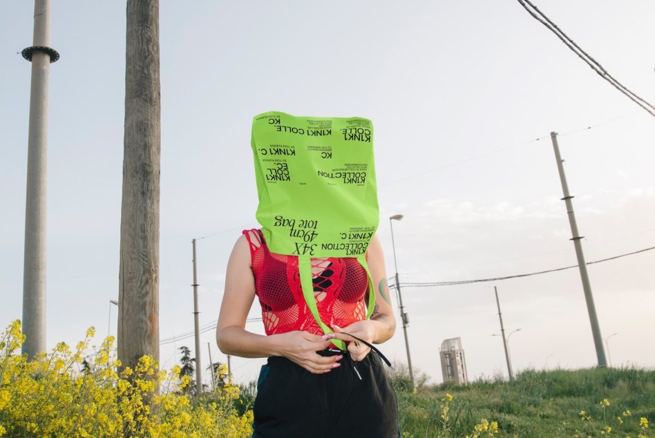 Person with fluorescent green bag on head in outdoor setting, creative concept for unique graphics or mockup content for designers.