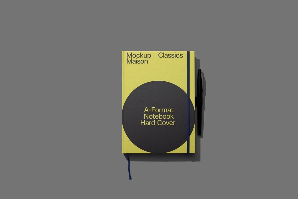 Compact yellow hardcover notebook with black circle, blue ribbon marker