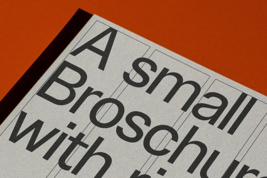 Close-up of a brochure mockup highlighting bold typography design on an orange background, perfect for graphic design and print templates.