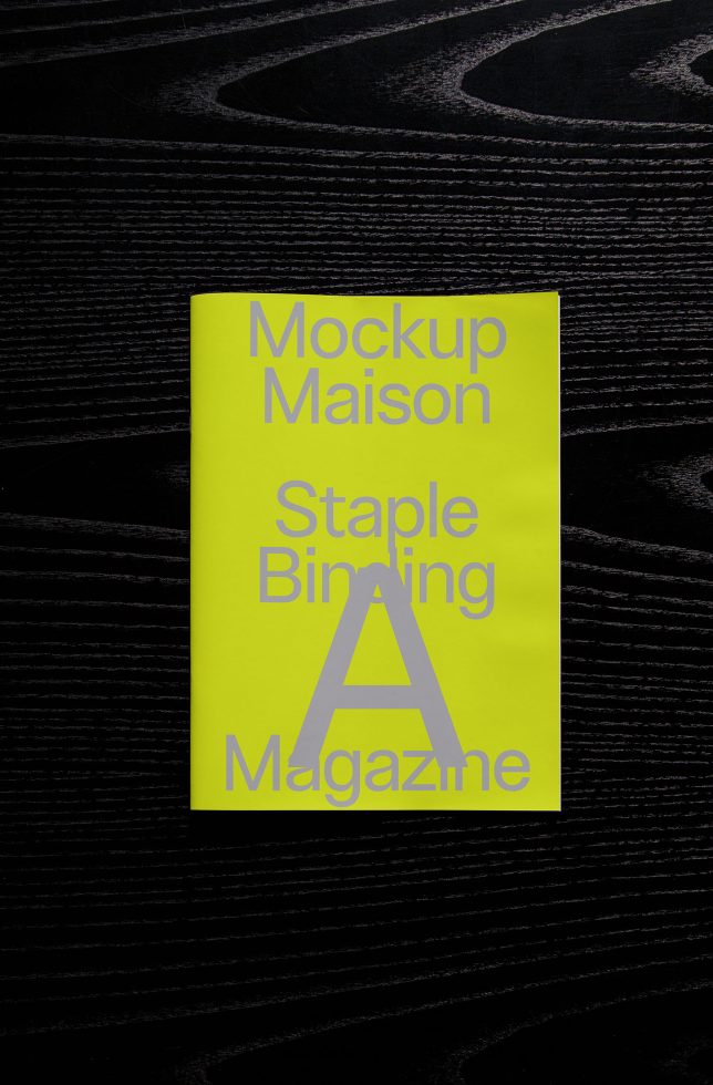 Bright yellow magazine mockup on textured dark surface showcasing modern graphic design for promotional layout and print design templates.