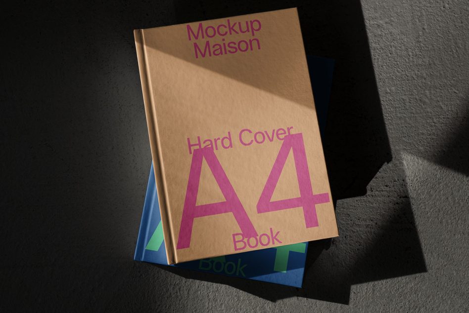 Kraft hardcover A4 book with pink typography stacked on colorful volumes