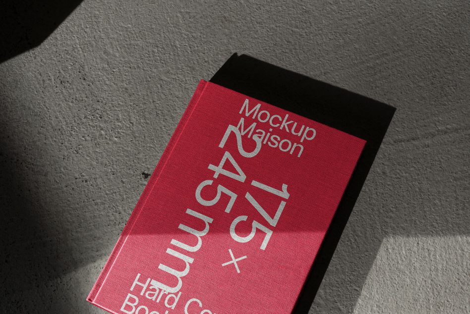 Hot pink A4 hardcover book mockup with silver foil text casting shadows