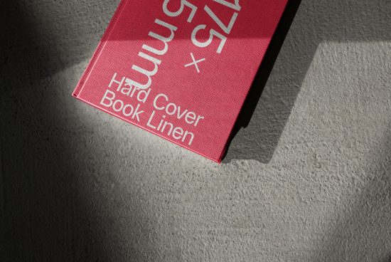 Red hardcover book mockup with linen texture in shadow and light contrast, perfect for book design presentations.