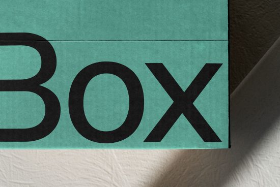Close-up of bold sans-serif font on teal box packaging, showcasing typography and design, ideal for mockups and graphic templates.