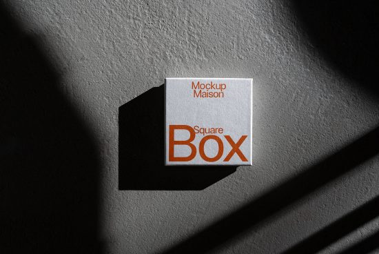 Realistic square box mockup with dramatic shadows on textured background for product design presentation, suitable for graphic designers.