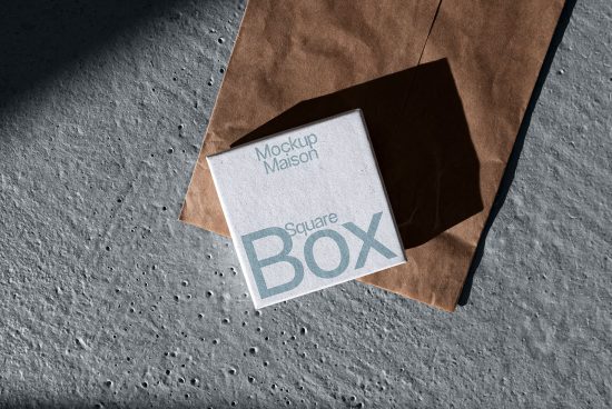 Elegant square box mockup with paper bag on textured concrete for product design, ideal for designers to showcase packaging mockups.