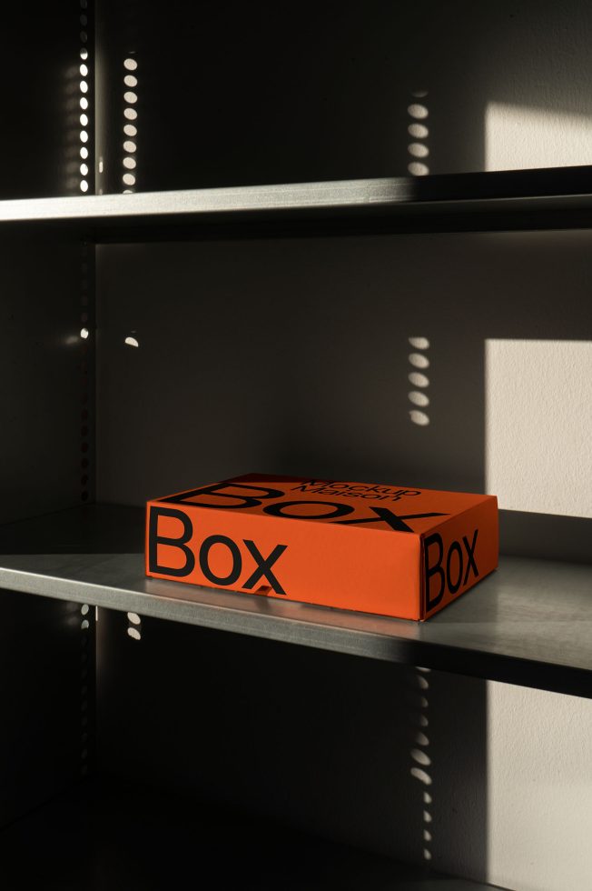 Orange packaging box mockup on a shelf with dramatic shadows, ideal for product design presentations, editable template.