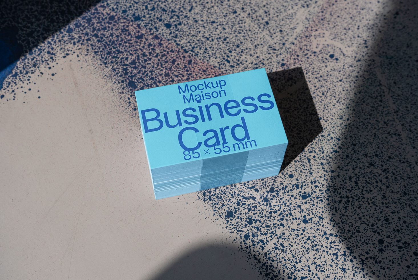 Business card mockup on terrazzo surface with shadow, showcasing design space for creative professionals, designers, 85x55mm size display.