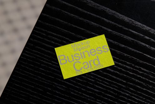 Bright yellow business card mockup on textured black background, design resource for graphic designers, editable template.