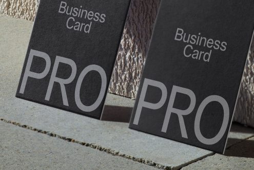 Elegant professional business card mockup with textured design, showcasing font and layout on dark paper, perfect for design presentations.