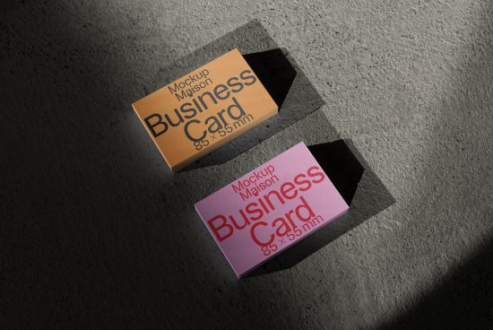 Two business card mockups on textured surface with natural shadows, orange and pink, for realistic branding design presentation.