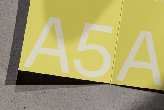 Yellow paper brochure mockup with letter A5, graphic design, print mockup, folded paper, minimalist, texture detail, close-up view, designers marketplace.