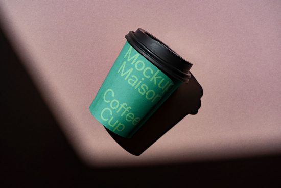 Green takeaway coffee cup mockup with shadow on a textured background, ideal for branding and design presentations.