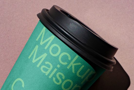 Close-up of a coffee cup mockup with a customizable green sleeve and black lid on a textured surface perfect for designers to showcase branding.