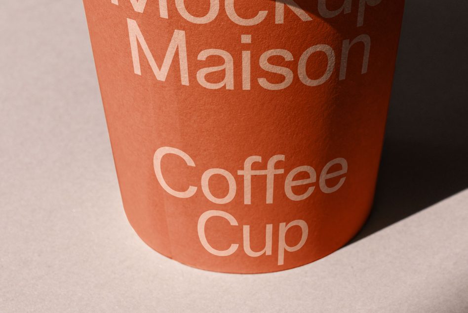 Realistic coffee cup mockup with typographic design, showcasing shadow play and texture details, perfect for presentations and branding.