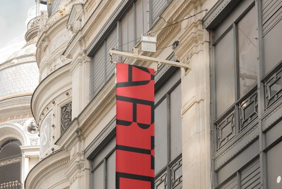 Red banner mockup hanging from a classic building facade, perfect for displaying design templates and graphics for urban outdoor advertising.