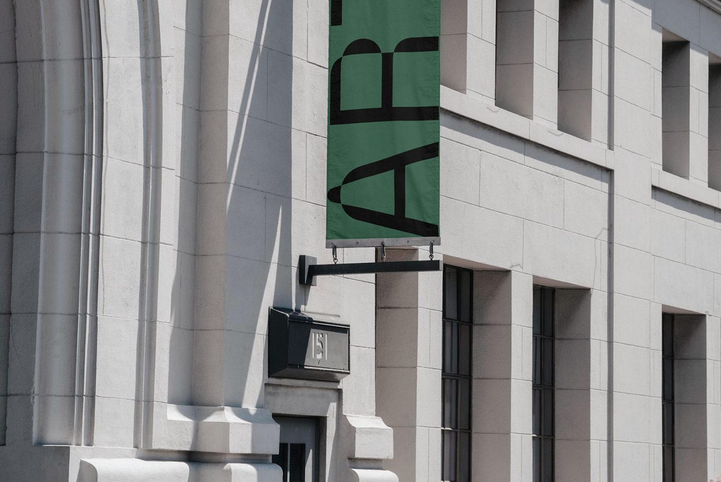 Modern building facade with hanging green banner mockup, shadow play on exterior walls, urban architecture design, templates category.