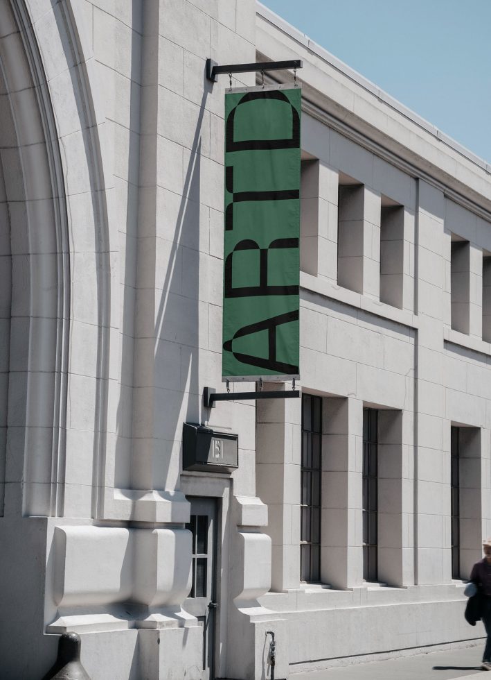 Outdoor banner mockup on urban building facade, showcasing bold font design, clear day, ideal for brand and logo presentations for designers.