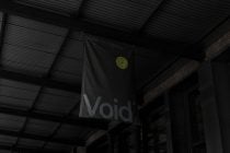 Black flag mockup hanging in dark industrial warehouse with yellow badge logo