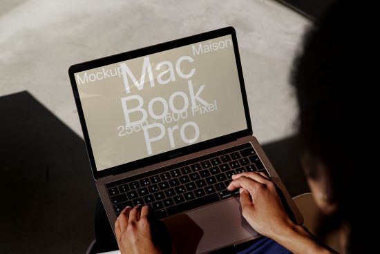 Laptop screen displaying 'Mockup MacBook Pro' text, suggesting a mockup template for presentations, with person working, designers asset.