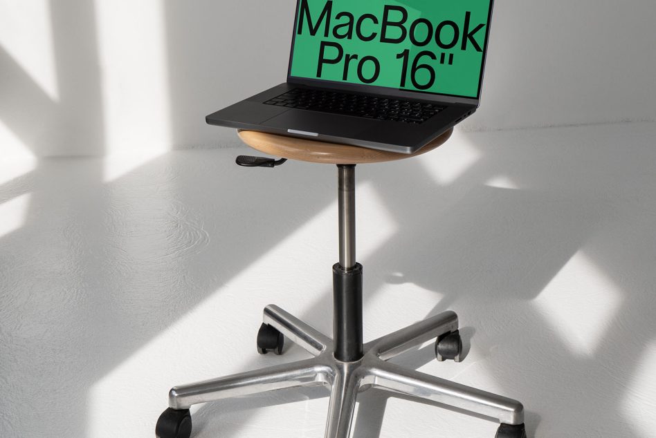 Laptop on modern stand with shadow play, ideal for mockup graphics. Perfect for designers featuring workspace and tech presentations.