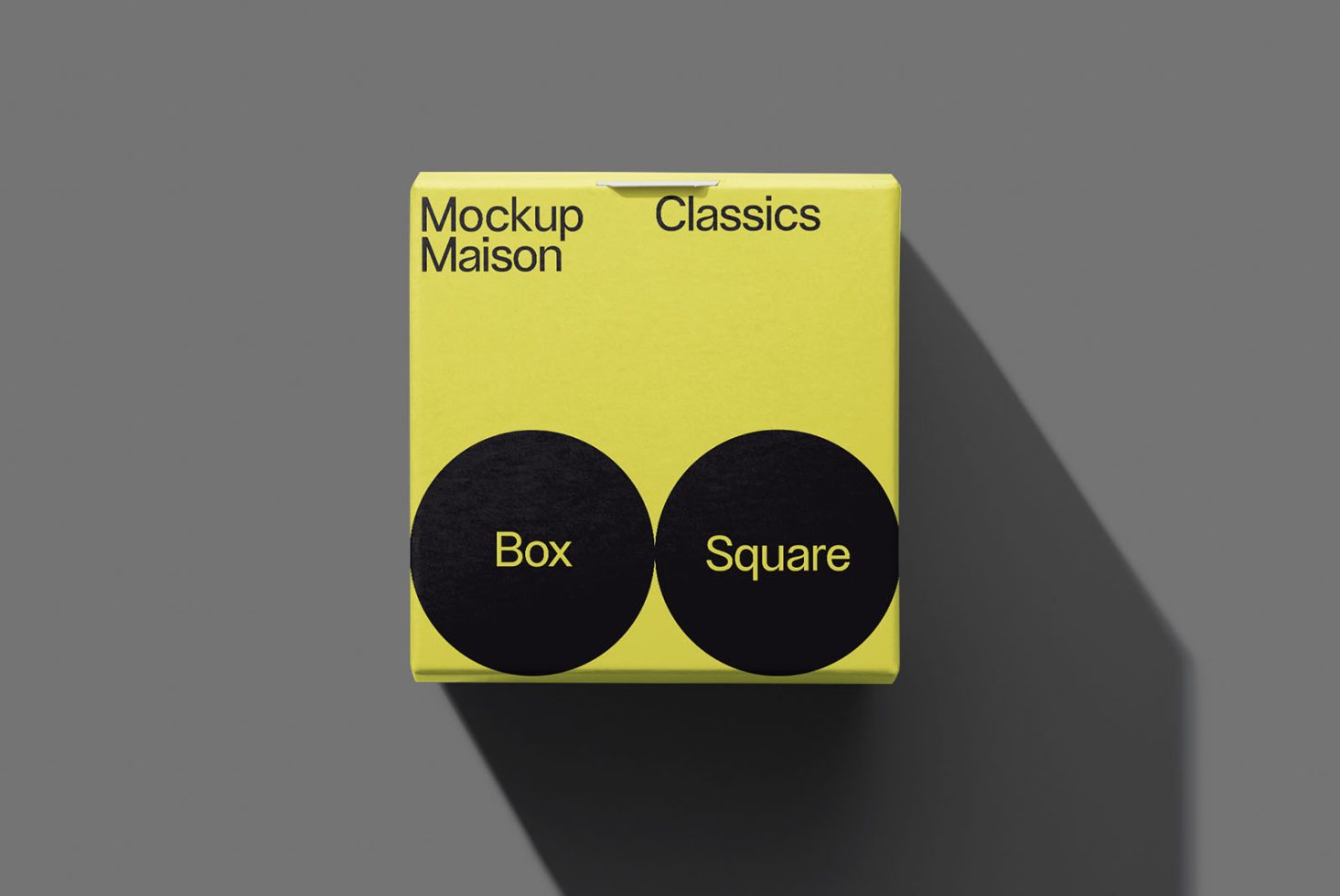 Yellow packaging box mockup with simple black circles design, labeled Mockup Maison Classics, on a grey background for designers.