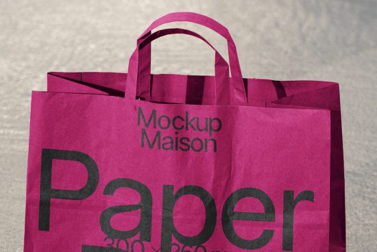Vivid magenta shopping bag mockup with text for branding, positioned on a textured gray surface, ideal for presentations and design showcases.