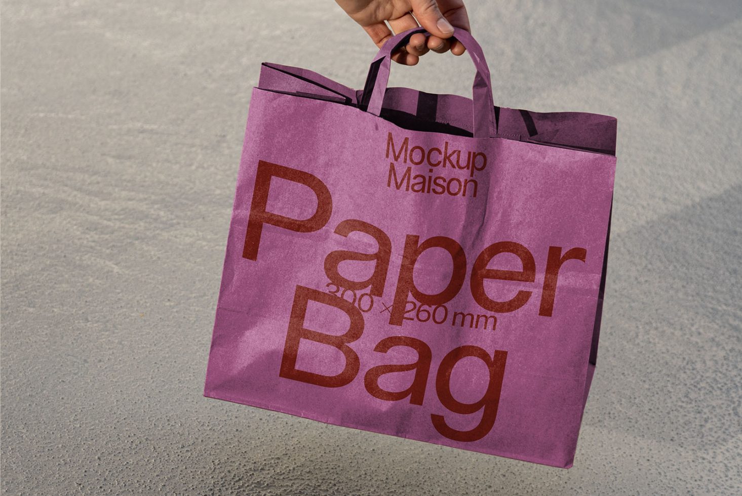 Hand holding purple paper bag mockup with typography on textured background, ideal for presentations and branding projects.