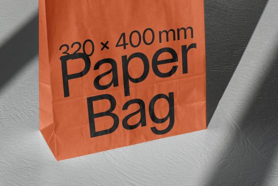Orange paper bag mockup on textured background casting shadows, showcasing design space, ideal for presentations, eco-friendly packaging.