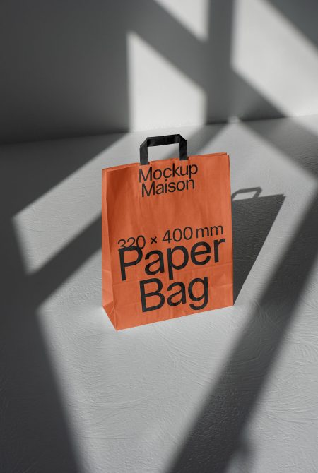 Orange paper bag mockup in sunlight with contrasting shadows on a smooth surface. Ideal for presentations and design showcases, high-quality packaging mockup.