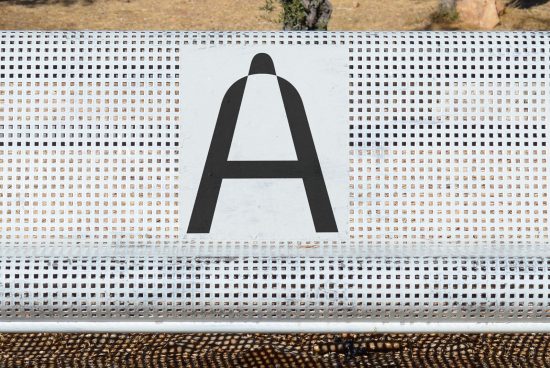 Bold letter A on perforated metal surface, graphic design, font style, black and white, clear typography, vector potential, creative background.