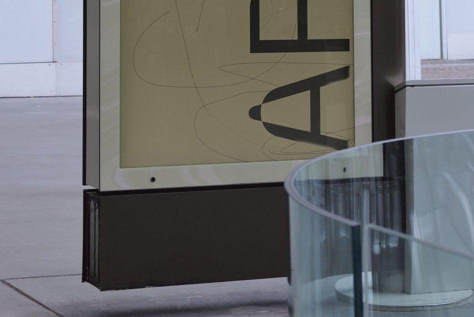 Horizontal view of lit display with layered black shapes on neutral backdrop