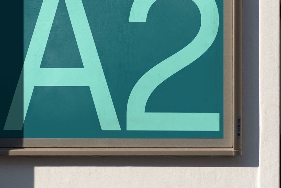 Close-up of large mint letter A2 on teal background framed on wall