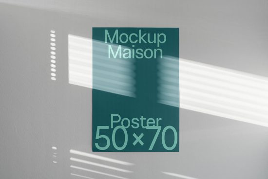 Modern poster mockup displayed on a wall with sunlight and shadow overlay, ideal for presenting design work and graphics.