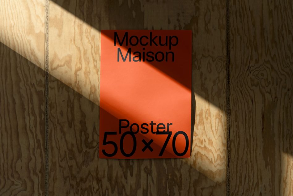 Bright orange poster with black text mounted on wood wall with natural light